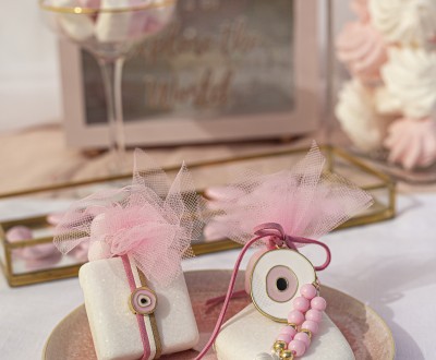 Μπομπονιέρες με βότσαλα, μεταλλικά στοιχεία μάτια, μακριά φούντα και ακρυλικές ροζ χάντρες