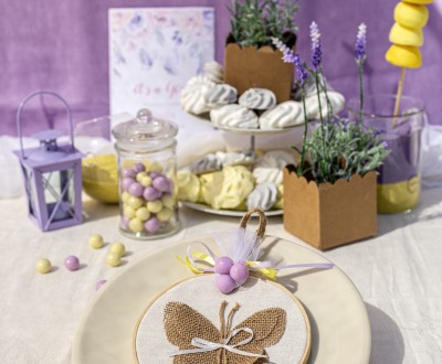 Μπομπονιέρα με ξύλινο τελάρο, πεταλούδα από γιούτα και διάφορες χρωματιστές κορδέλες