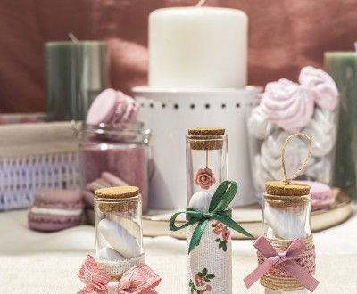 Μπομπονιέρες με μπουκαλάκια σε διάφορα μεγέθη διακοσμημένες με διάφορα υφάσματα, τριαντάφυλλο και κορδέλες