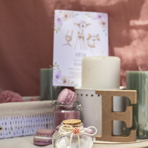 Μπομπονιέρα με διάφανο μπουκαλάκι σε σχήμα καρδιάς διακοσμημένη με ξύλινες πολυγωνικές χάντρες, τριανταφυλλάκι και μπεζ σπάγγο