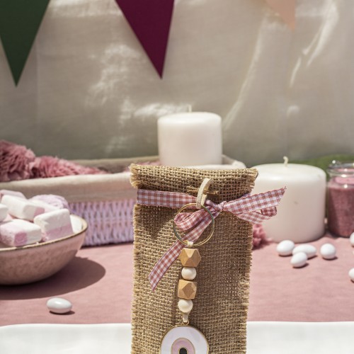 Μπομπονιέρα με γιούτα σε σχήμα φάκελο διακοσμημένη με μεταλλικό στοιχείο μάτι σε μπρελόκ και διάφορες χάντρες