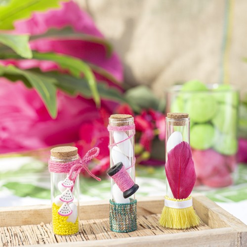 Μπομπονιέρες με διάφανα μπουκαλάκια σε διάφορα μεγέθη διακοσμημένες με φτερό, κουβαρίστρα, φίμο καρπούζι και διάφορες κορδέλες