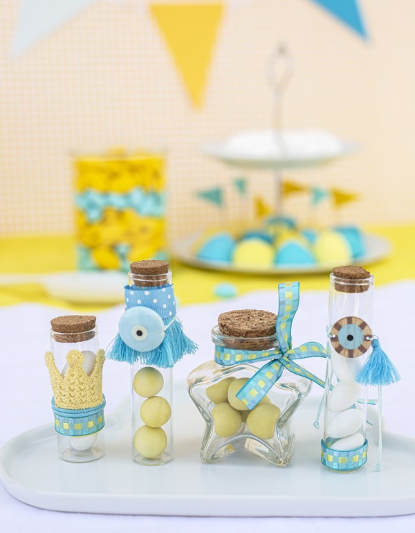 Μπομπονιέρες με διάφανα μπουκαλάκια σε διάφορα μεγέθη και σχήματα διακοσμημένες με κεραμικό και ξύλινο στοιχείο ματάκι, διάφορες κορδέλες και τρέσες