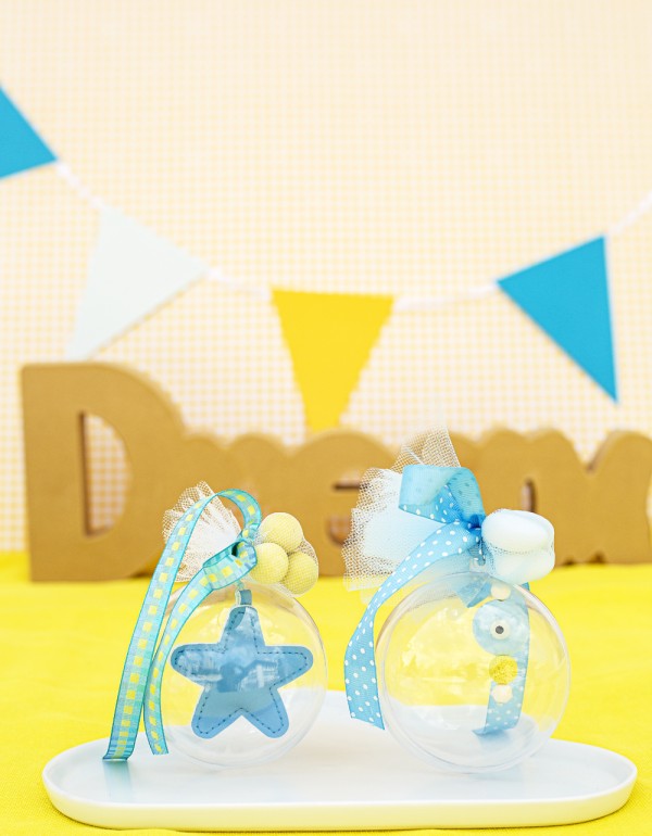 Μπομπονιέρες με διάφανο κουτί σε σχήμα μπάλας διακοσμημένες με υφασμάτινο αστέρι, κεραμικό στοιχείο μάτι και διάφορες κορδέλες