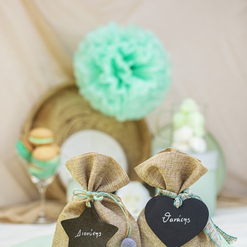 Μπομπονιέρες με πουγκί τσουβαλέ διακοσμημένες με ξύλινα στοιχεία πίνακα σε σχήμα καρδιάς και αστέρι, μπάλες πομ πομ και διάφορα κορδόνια