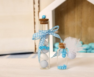 Μπομπονιέρες με διάφανα μπουκλάκια σε διάφορα μεγέθη διακοσμημένες με ακρυλικά στοιχεία μουστάκι και πιπίλα και καρό κορδέλα