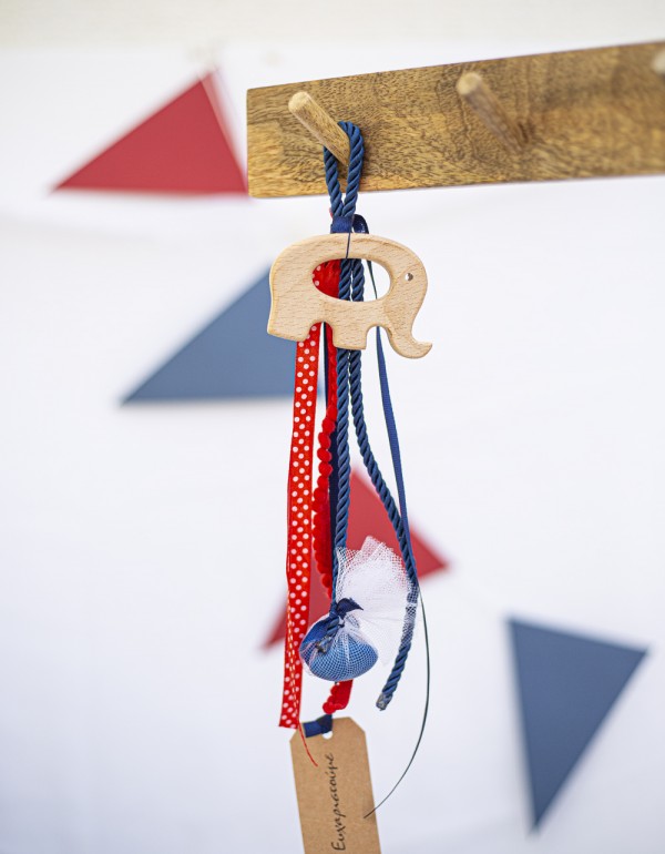 Κρεμαστή μπομπονιέρα με ξύλινο στοιχείο ελεφαντάκι διακοσμημένη με ρεγιόν κορδόνι, τρέσα με πον πον και διάφορες κορδέλες