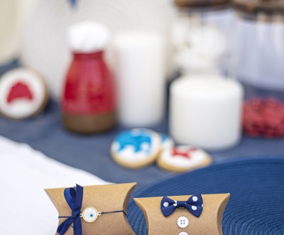 Μπομπονιέρες με craft κουτάκια διακοσμημένες με μεταλλικό μοτίφ, υφασμάτινο πουά φιόγκο, λευκό κουμπί και σατέν κορδέλα