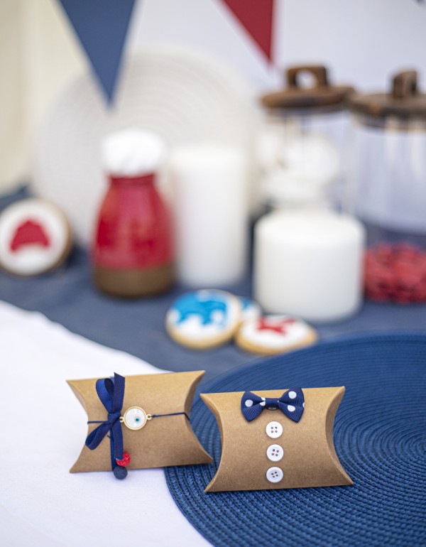 Μπομπονιέρες με craft κουτάκια διακοσμημένες με μεταλλικό μοτίφ, υφασμάτινο πουά φιόγκο, λευκό κουμπί και σατέν κορδέλα