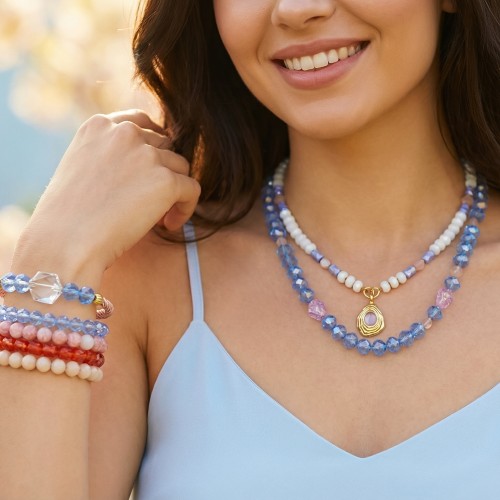 Κολιέ και βραχιόλια με κρύσταλλα σε αποχρώσεις του μπλε και του λευκού, που χαρίζουν κομψότητα και φρεσκάδα, συνδιασμένα με χρυσό αιματίτη, χρυσά στοιχεία όπου η διακριτική χρυσή λεπτομέρεια δημιουργούν ένα μοντέρνο και φωτεινό αποτέλεσμα