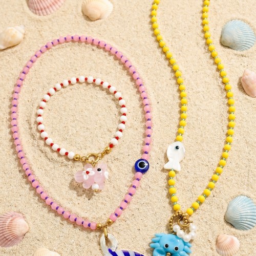 Κολιέ και βραχιόλι που συνδυάζει playful χαρακτήρα και μοντέρνα αισθητική, με γυάλινες χρωματιστές πέτρες, κρύσταλλα, πέρλες, χρυσό αιματίτη και στοιχεία μουράνο