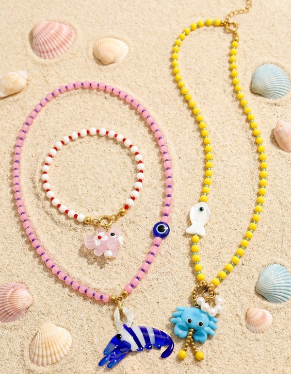 Κολιέ και βραχιόλι που συνδυάζει playful χαρακτήρα και μοντέρνα αισθητική, με γυάλινες χρωματιστές πέτρες, κρύσταλλα, πέρλες, χρυσό αιματίτη και στοιχεία μουράνο