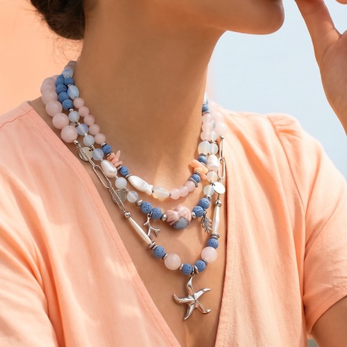 Κολιέ σε σομόν αποχρώσεις συνδιασμένα με ασημί αιματίτη, λάβα, φεγγαρόπετρα, ροζ χαλαζία, κοράλι, κεραμικό στοιχείο, ασημί αλυσίδα, μαργαριτάρια και ασημί θαλασσινά στοιχεία